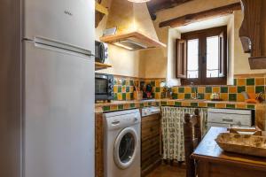 a kitchen with a refrigerator and a washing machine at El Porton in Borge