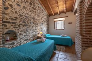 a room with two beds and a stone wall at El Porton in Borge
