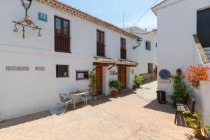 a courtyard of a white building with a table and chairs at El Porton in Borge