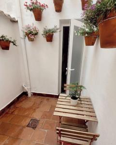a porch with a bench and potted plants on the wall at Casa Tonino: Encantadora casa junto al Río Duero in Zamora