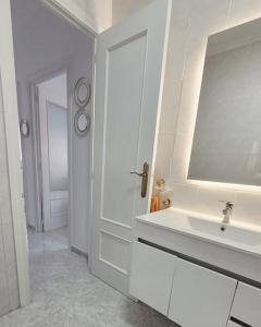 ein weißes Badezimmer mit einem Waschbecken und einem Spiegel in der Unterkunft Casa Tonino: Encantadora casa junto al Río Duero in Zamora
