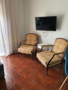 twee stoelen en een flatscreen-tv in een kamer bij Barra's Beach Apartment in Praia da Barra