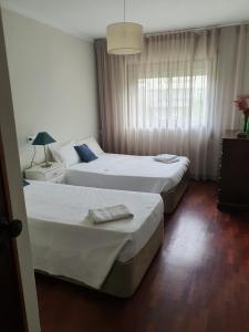 1 dormitorio con 2 camas y ventana en Barra's Beach Apartment, en Praia da Barra
