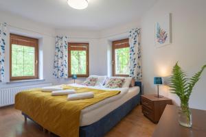 a bedroom with a large bed with yellow sheets at Willa Wieżyczki in Świeradów-Zdrój