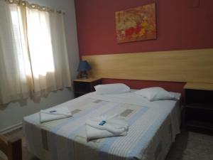 um quarto com uma cama com toalhas em Hotel Venice Ubatuba em Ubatuba