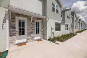a row of houses with white doors on a street at Charming Disney Vacation Home - 5 bedrooms in Orlando