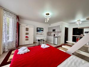 a bedroom with a red blanket on a bed at Raduga West 'Amber' Apartment in Koshkolʼ