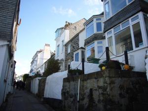 a street with houses on the side of a alley at 10 The Warren, amazing seaviews from every floor! in St Ives