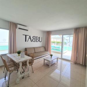 a living room with a couch and a table at Tabbu ibiza apartments in Playa d'en Bossa
