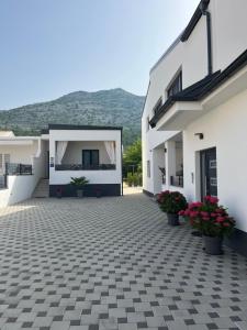 a white house with a courtyard with flowers at Holiday house Aria di Mare in Starigrad-Paklenica