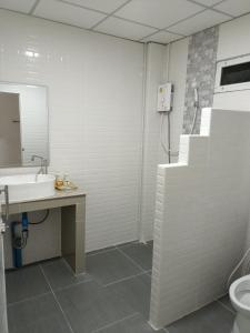 uma casa de banho com um lavatório, um WC e um espelho. em โรงแรม เดอะพีช / The Peach hotel em Phetchaburi