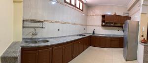 a large kitchen with a sink and a refrigerator at Al houceima in Al Hoceïma
