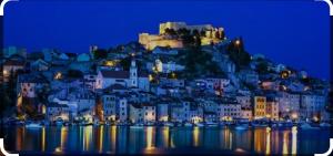 a town on top of a mountain at night at Apartman Lucia in Bilice