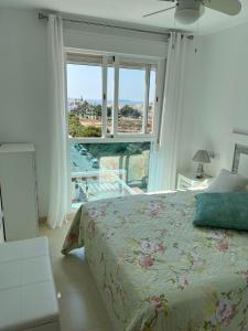 - une chambre avec un lit et une grande fenêtre dans l'établissement Ático con piscina privada vistas al mar., à Vera