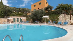 a large pool with chairs and umbrellas in front of a building at Il Borgo in Finale Ligure