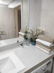 a bathroom with a sink and a mirror and towels at Bella apartman in Mladenovac