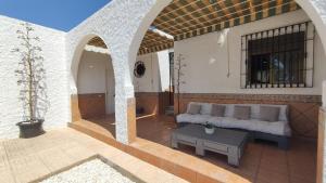 a living room with a couch and a table on a patio at Chalet "El Paraíso del Cabo" Retamar El Toyo Golf in Retamar