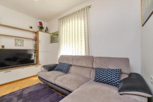 uma sala de estar com um sofá e uma televisão de ecrã plano em SNJEŽANA em Mali Lošinj