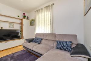 a living room with a couch and a flat screen tv at SNJEŽANA in Mali Lošinj