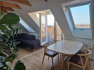 uma sala de estar com uma mesa e cadeiras e um sofá em Aarhus Penthouse em Arhus