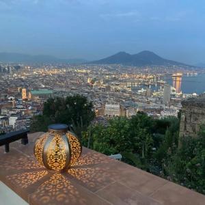 un vase assis sur une table avec vue sur une ville dans l'établissement Le Petit Palais - Naples, à Naples