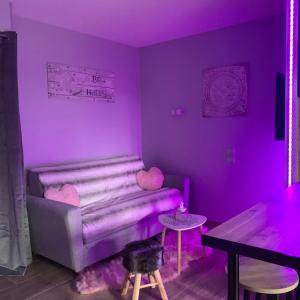 - un salon violet avec un canapé et une table dans l'établissement Studio climatisé avec piscine, à Saint-Raphaël