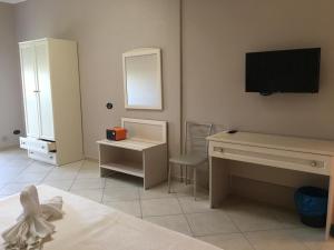 a bedroom with a desk and a television on the wall at Il Tempio Di Hera in Marinella di Selinunte