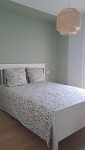 a bedroom with a white bed and a white table at Maison paisible et ensoleillée in Avignon