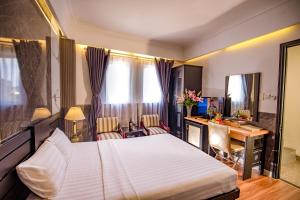 Pokój hotelowy z łóżkiem i biurkiem w obiekcie Rosa Hotel & Spa w Ho Chi Minh