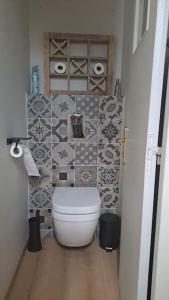 a bathroom with a toilet and tiles on the wall at Maison paisible et ensoleillée in Avignon