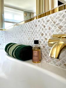a bottle of perfume sitting on a shelf in a bathroom at Gold Apartments Jacuzzi Room in Częstochowa +17 photos