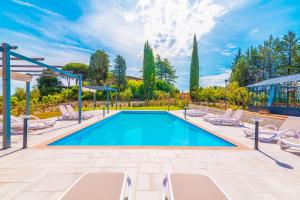 a swimming pool with chaise lounge chairs and a resort at Villa La Pieve in Città della Pieve