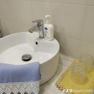 a bathroom sink with a bottle of soap on it at B&B SA CROBE in Lanusei