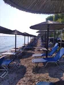 eine Reihe von Stühlen und Sonnenschirmen am Strand in der Unterkunft Eri's House 