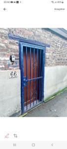 een blauwe deur aan de zijkant van een bakstenen gebouw bij Le Studio Baltard in Charleroi
