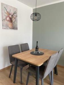 a dining room table with four chairs and a lamp at Apartman Stela in Knin