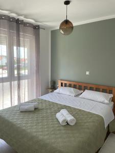 a bedroom with a large bed with two towels on it at Apartman Stela in Knin