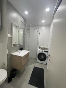 a bathroom with a sink and a washing machine at Apartman Stela in Knin
