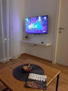 a living room with a table with a television on a wall at Apartman Stela in Knin