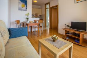 ein Wohnzimmer mit einem Sofa und einem Tisch in der Unterkunft Apartman Vlado in Vrsar