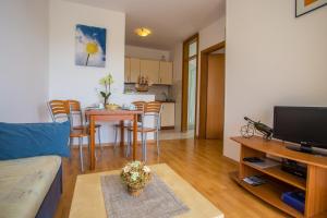 ein Wohnzimmer mit einem Sofa und einem Tisch mit Stühlen in der Unterkunft Apartman Vlado in Vrsar