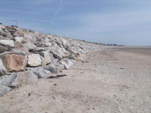 eine Gruppe Felsen am Strand in der Unterkunft C'est une maison bleue, juste à côté de la plage... in Barneville-Carteret