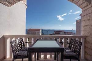 a table and chairs on a balcony with a view at Apartmani Baki 1 in Podstrana