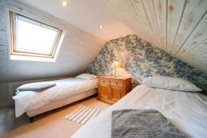 a bedroom with two beds and a window at Mrs Moll's Cottage in Earlston