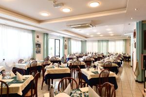 uma grande sala de jantar com mesas e cadeiras em Hotel Criniera D'oro em Rimini