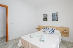 a white bed with two pillows on top of it at Azahar Fibes in Seville