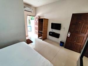 a bedroom with a bed and a flat screen tv at Calangute Turista in Calangute