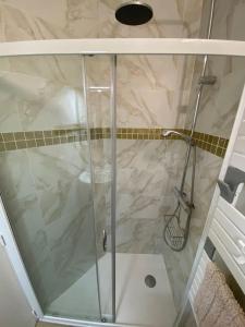 eine Dusche mit Glastür im Bad in der Unterkunft Au coeur de Brantôme : superbe appartement in Brantôme