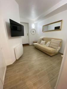 ein Wohnzimmer mit einem Sofa und einem Flachbild-TV in der Unterkunft Au coeur de Brantôme : superbe appartement in Brantôme