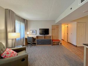 uma sala de estar com um sofá e uma televisão de ecrã plano em Candlewood Suites Indianapolis Downtown Medical District, an IHG Hotel em Indianápolis